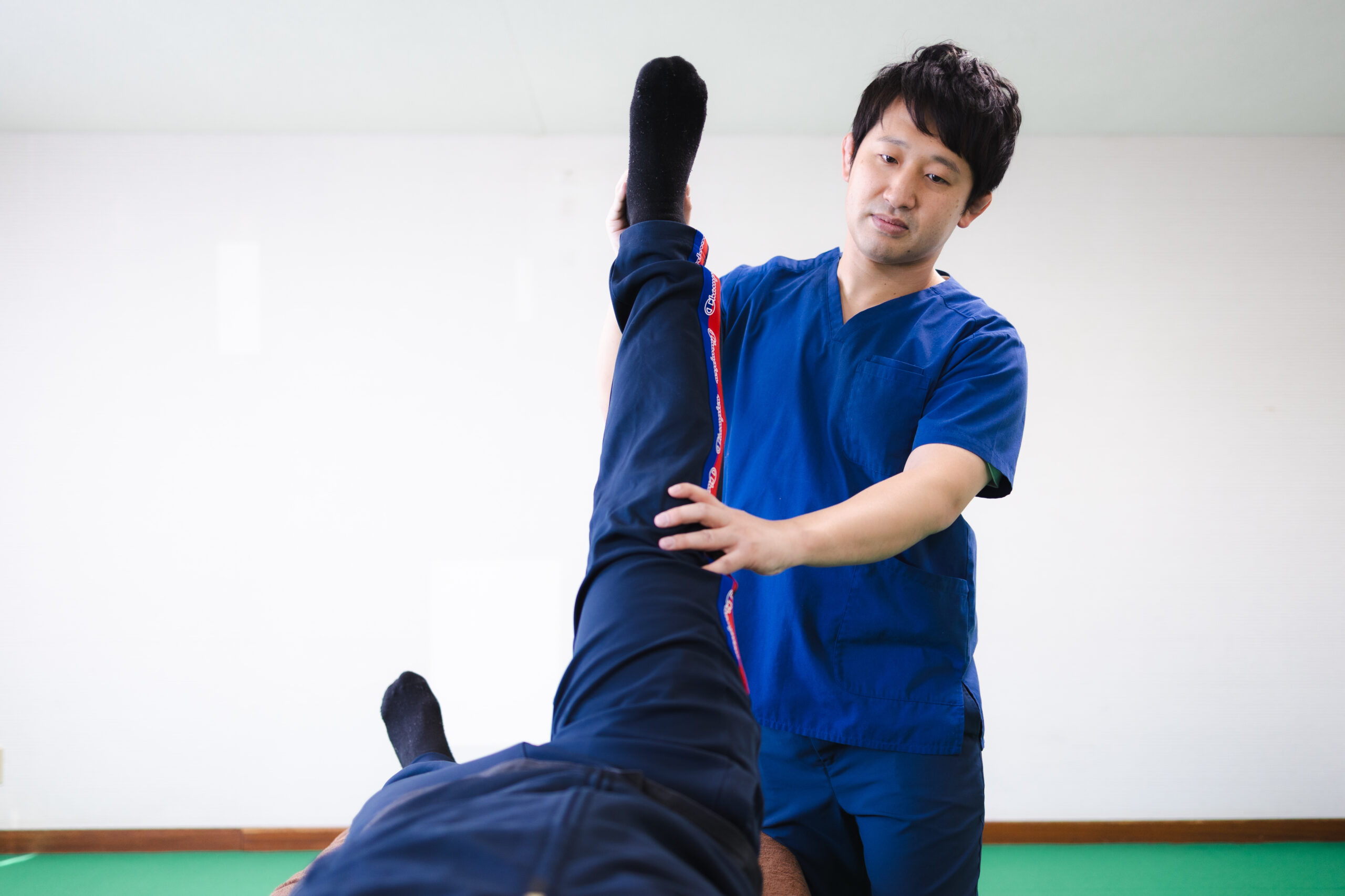 仰向けで脚を上げて身体の動きを確認する様子