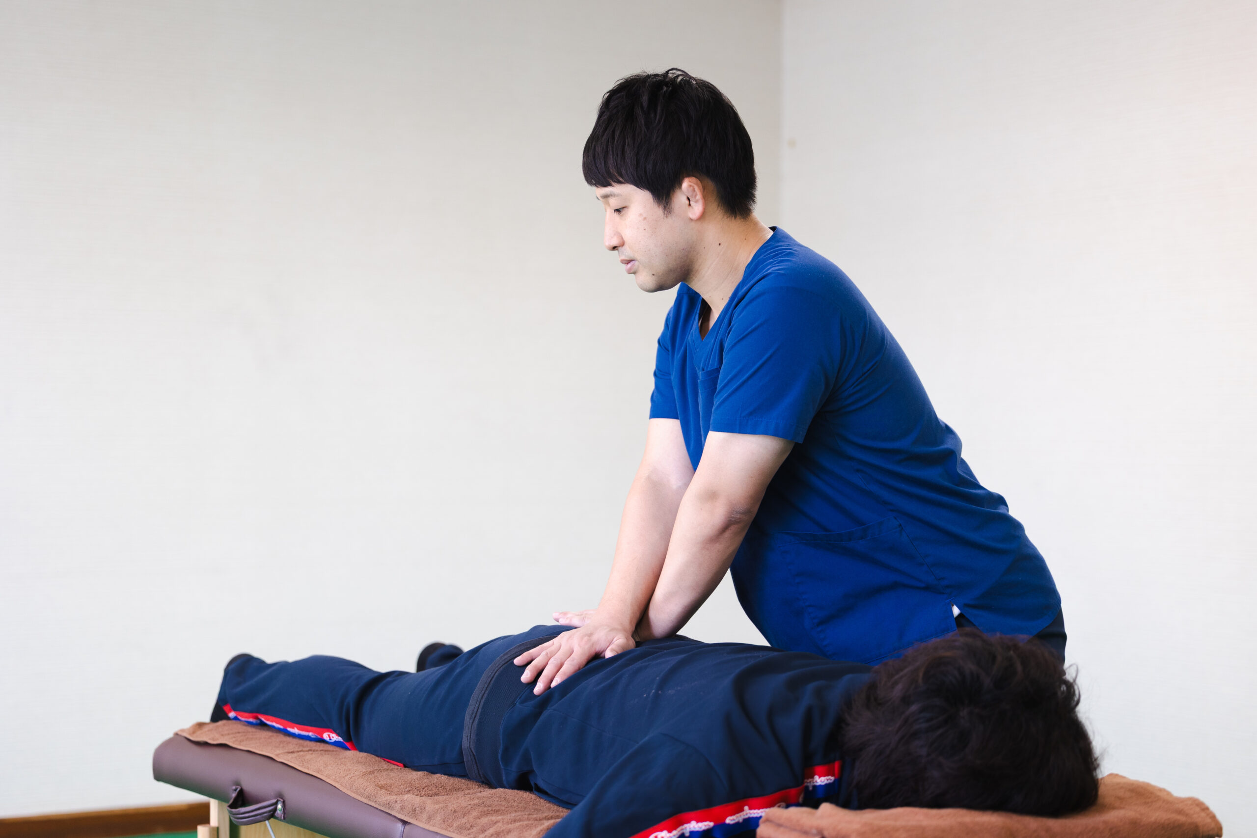 うつ伏せで背中の施術を受ける様子